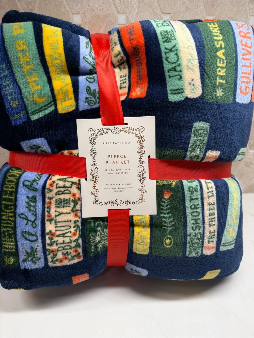 Rifle Paper Co. Navy Fleece Throw with Colorful Book Spine Print